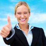 Happy blond business woman showing thumbs up